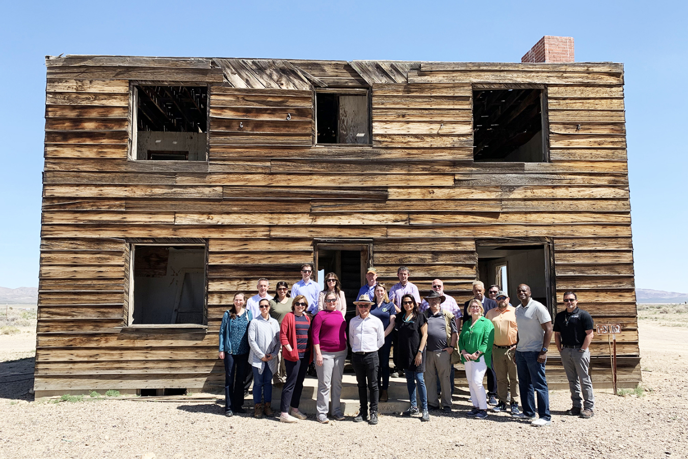 A group of people in front of the Apple 2 house, one of the "Doom Town" homes used in a 1955 above-ground nuclear test.