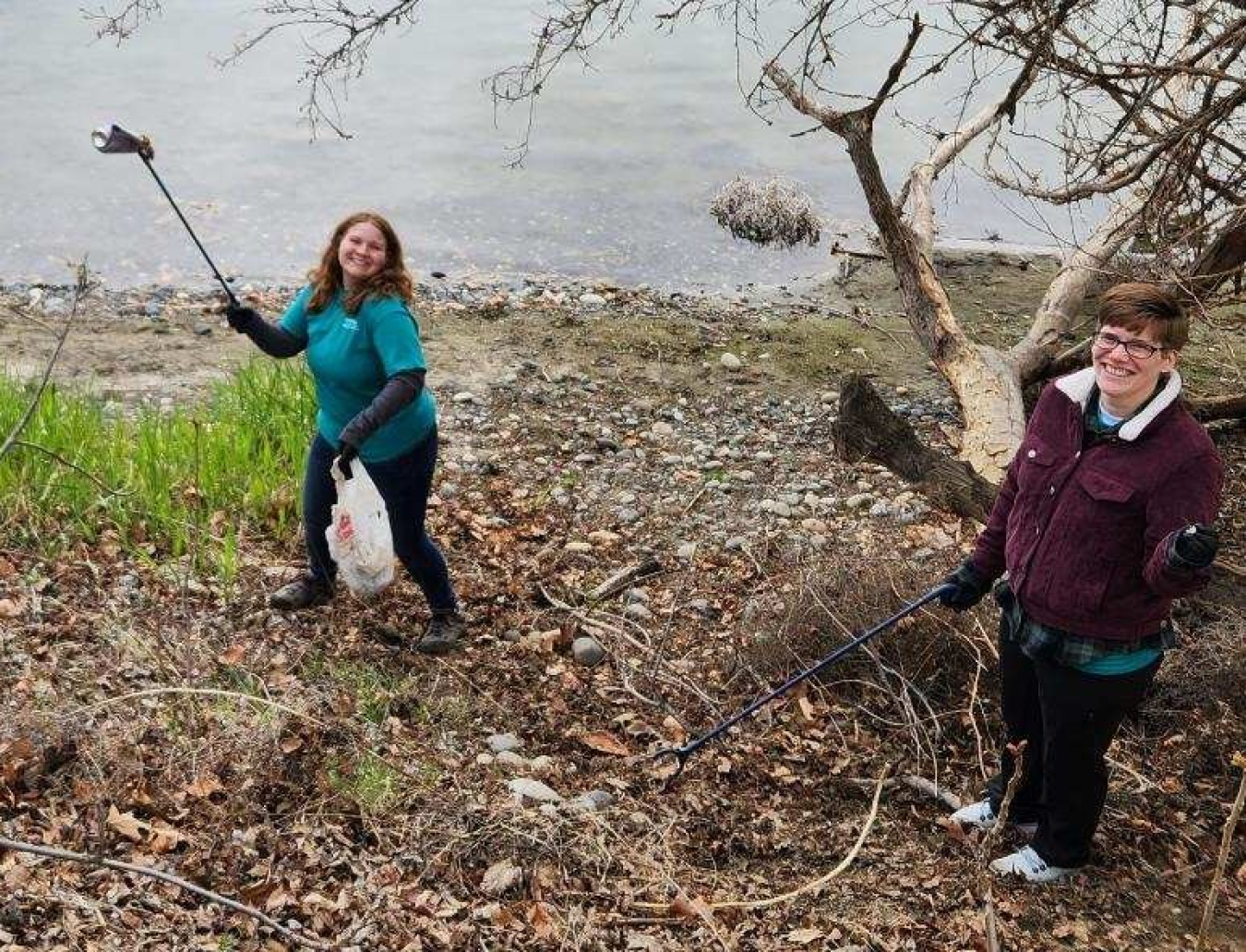 Volunteers Catherine Fewell, left, and Elyse Frohling with Hanford Site contractor Central Plateau Cleanup Company pick up litter and other items along the banks of the Columbia River during a One Hanford Earth Day cleanup event in Richland, Washington. 