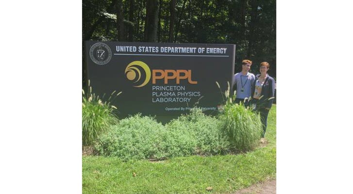 Marion Smedberg and another person standing by the Princeton Plasma Physics Laboratory sign