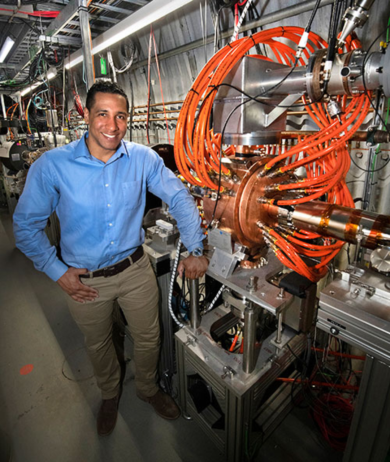 Brutus standing next to a warm radiofrequency cavity he helped design for the LEReC experiment at RHIC.