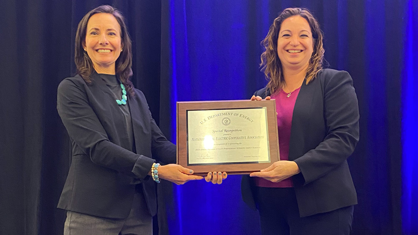 Two women holding a plaque of special recognition.