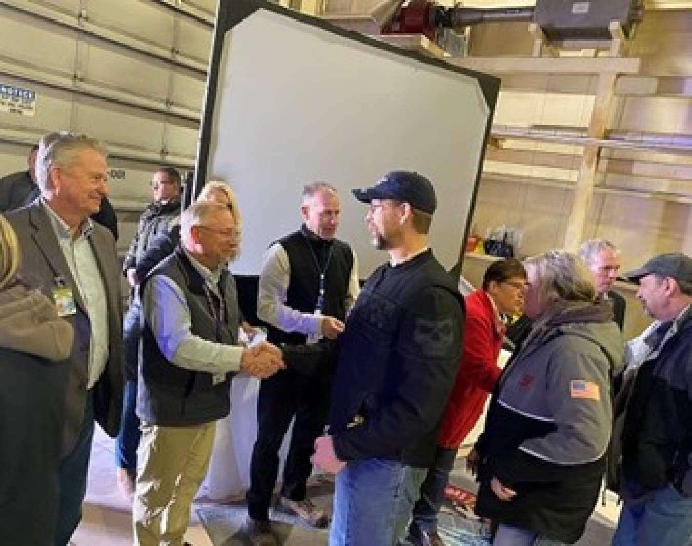 Idaho Gov. Brad Little, far left, and other officials shake hands with members of the work-force, thanking them for their hard work and help meeting a major cleanup milestone.