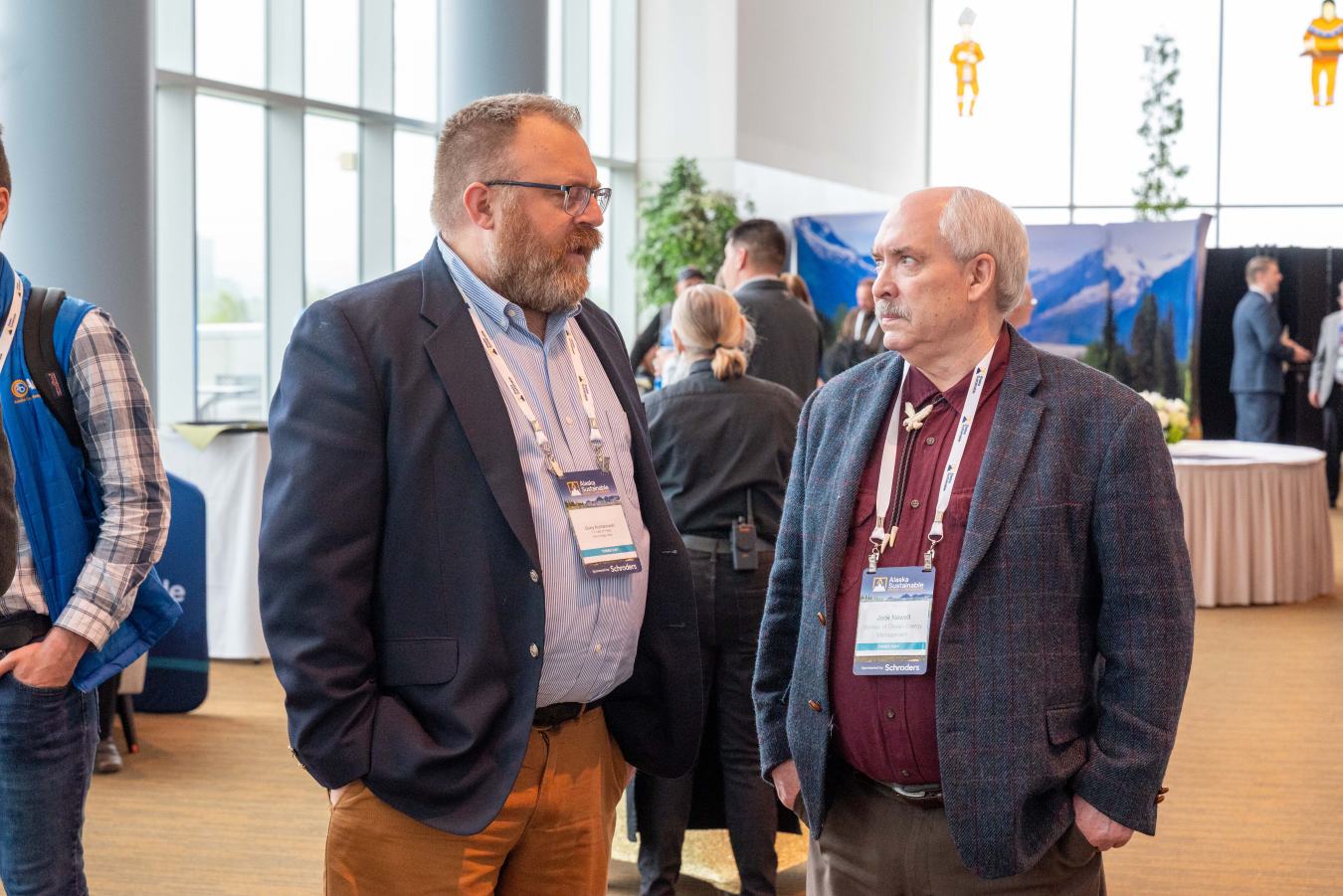 Givey, Senior Advisor in the Arctic Energy Office, is on the left, speaking with an attendee at the Alaska Sustainable Energy Conference in May 2023.