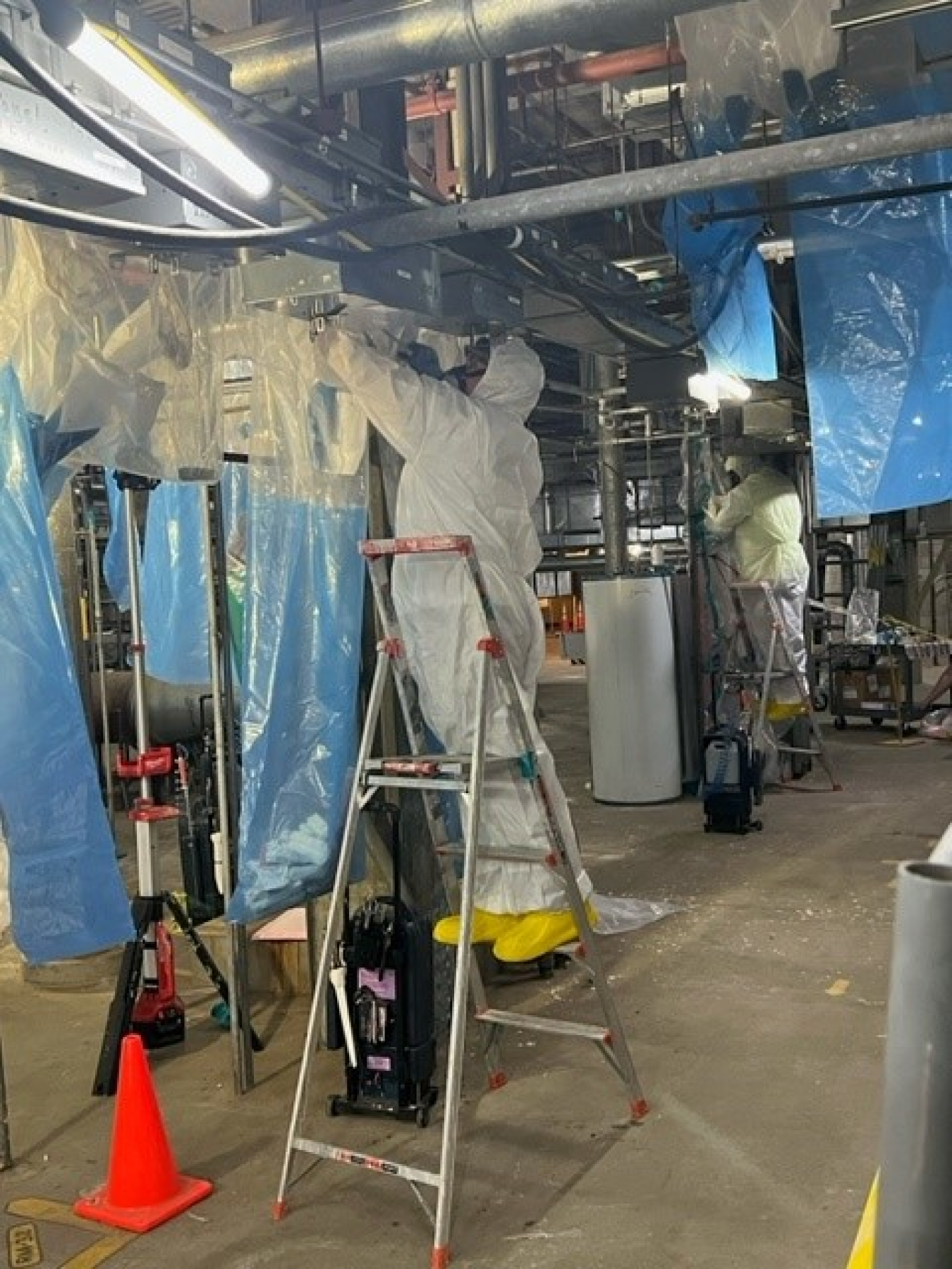 Workers with EM contractor Central Plateau Cleanup Company use glove bags to safely remove asbestos insulation from piping at the 231-Z Building. Crews are preparing the historic Hanford Site building for demolition.