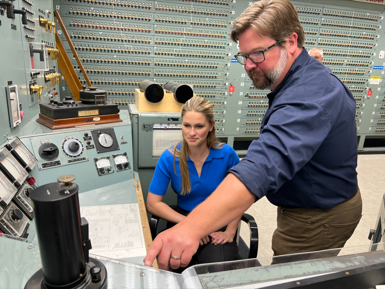 B Reactor National Historic Landmark Operations Manager Patrick Jaynes with contractor Central Plateau Cleanup Company briefs nuclear engineering student and Miss America 2023 Grace Stanke in the B Reactor control room.