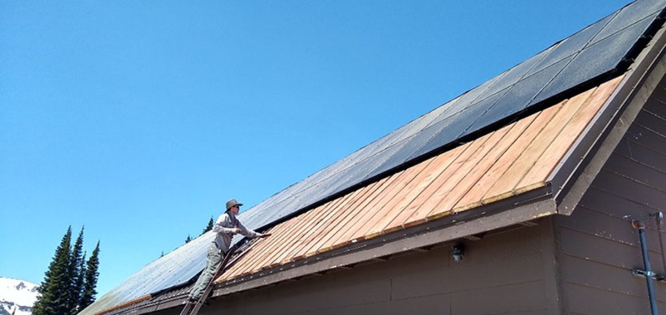 Photo of a person working on a roof.