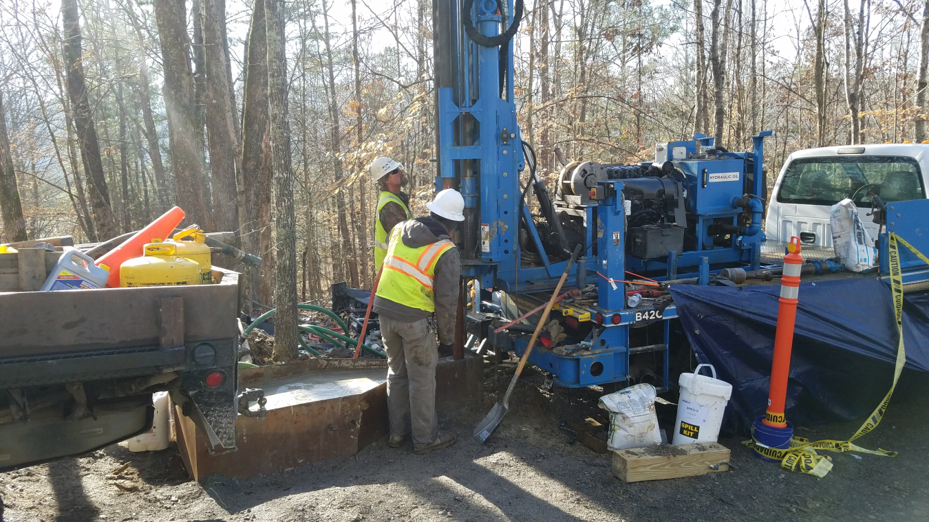 workers drill wells for groundwater sampling