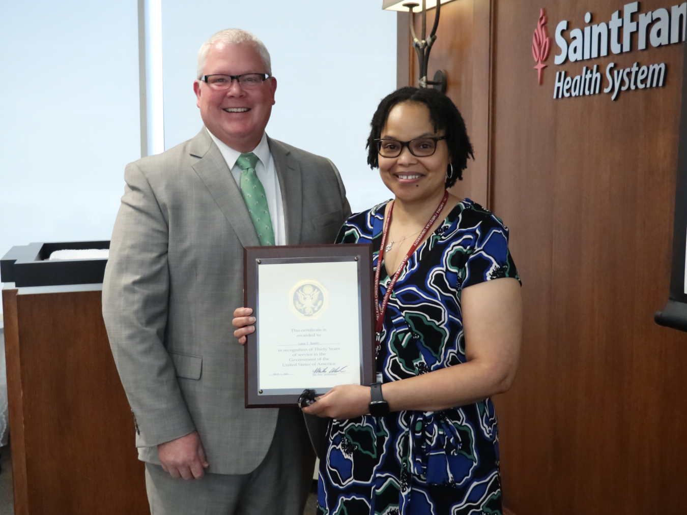 Program coordinator, Lona Smith, holding a plaque presented by Mike Wech.