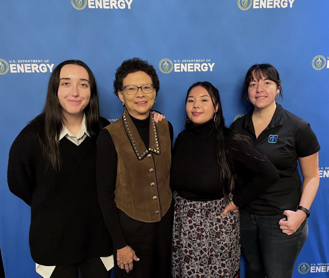 Three interns pose with their mentor.