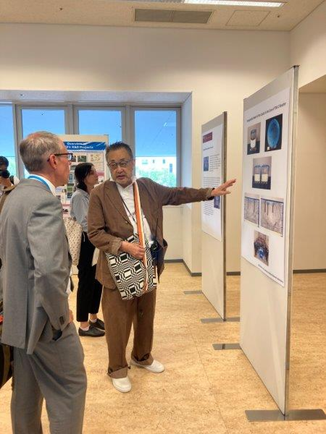 Masaki Nakagawa, special adviser to executive directors, NDF and Ike White, EM senior advisor, look at a technical abstract poster during day two of the forum that was produced in collaboration with the Idaho National Laboratory. 