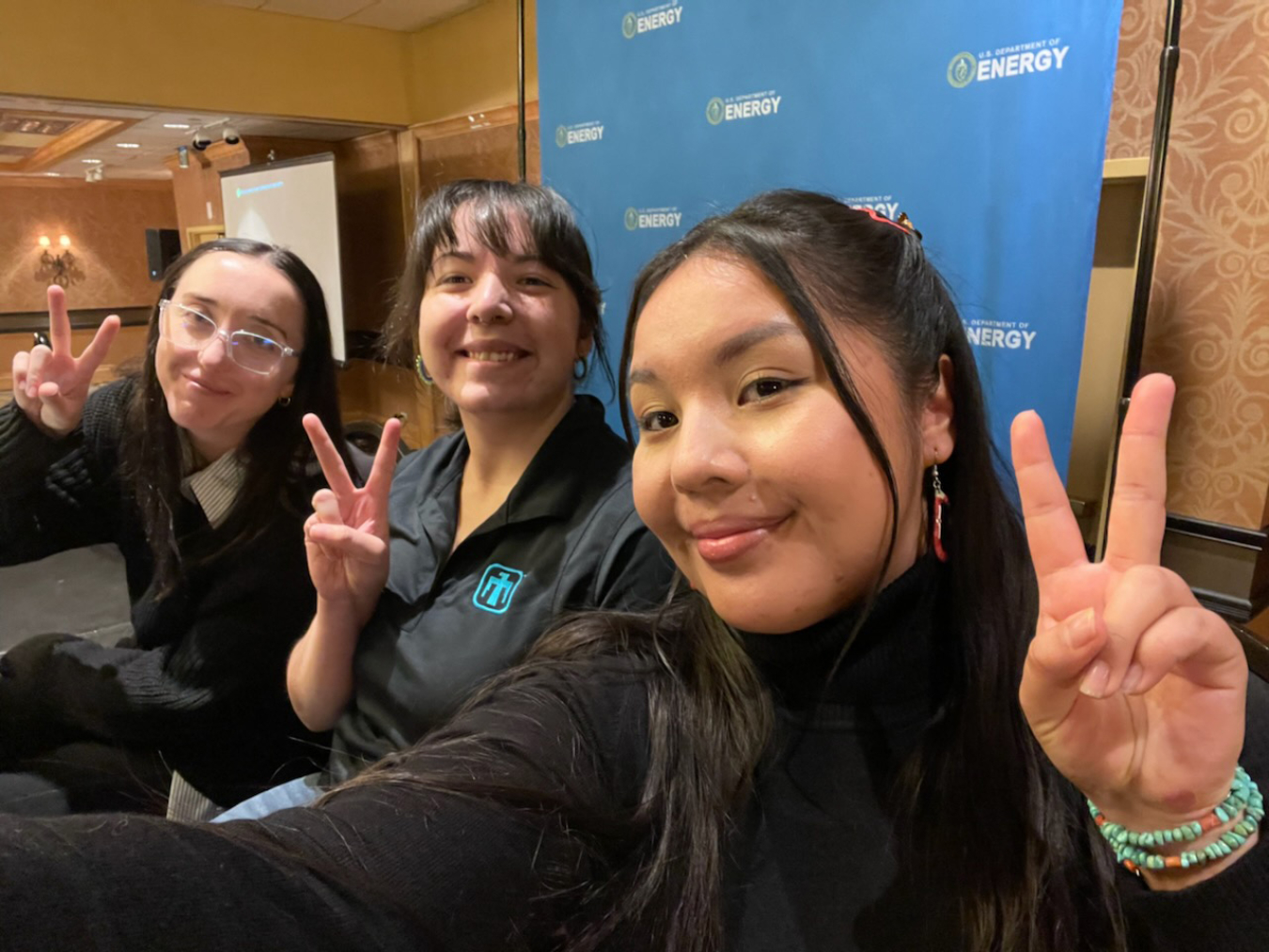 Three women pose for a group selfie.