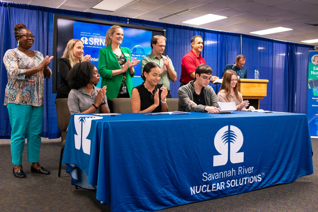 Savannah River Nuclear Solutions (SRNS) Internship Program students sign and accept their full-time position offers at the Savannah River Site with support from SRNS executives, managers and mentors who aided in their success.