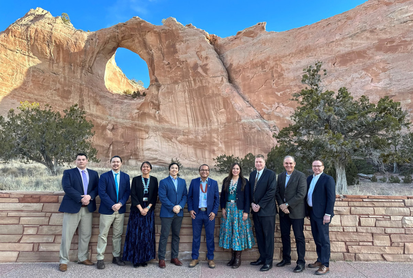 A group of politicians pose in front of the Window Rock formation in Arizona.