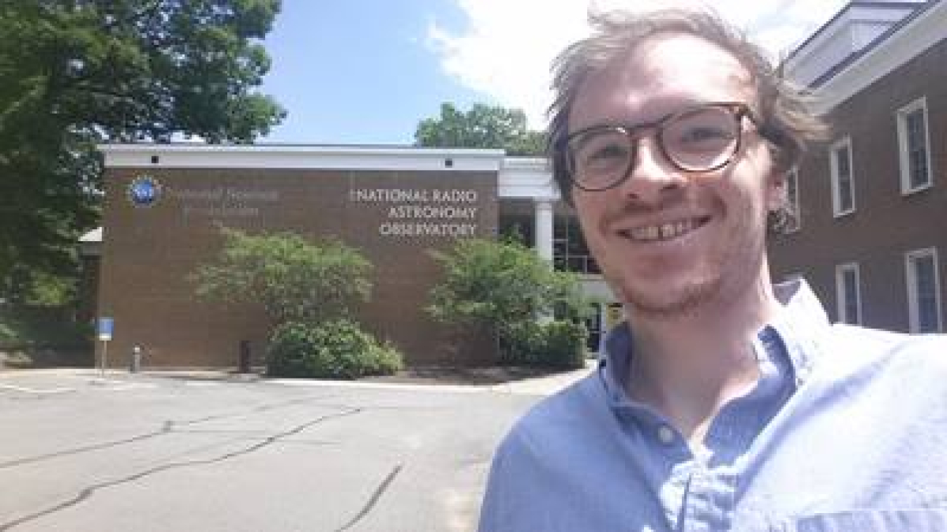 Tristan Ashton taking a selfie in front of the National Radio Astronomy Observatory