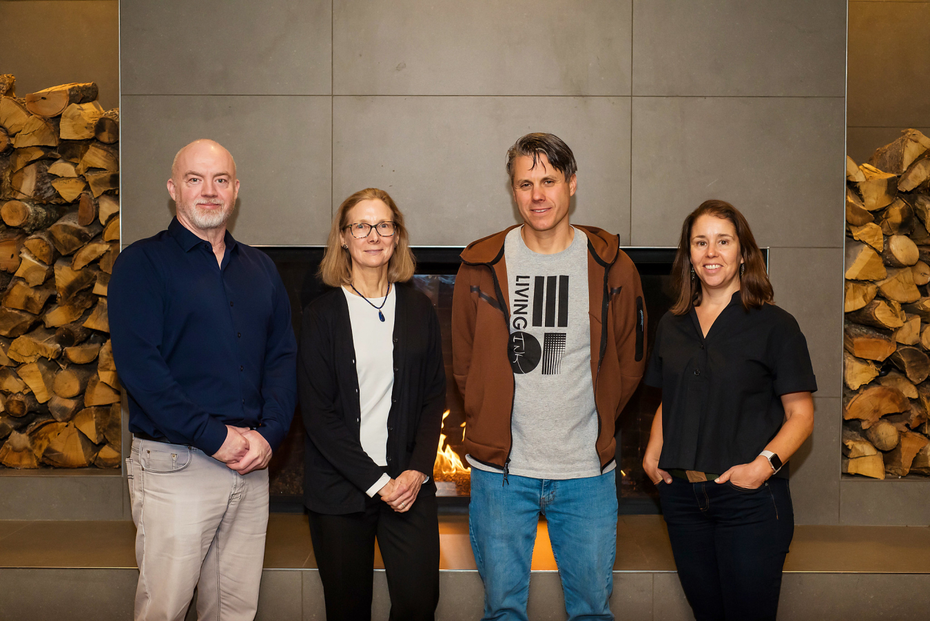 A group of four people pose and smile for the camera.