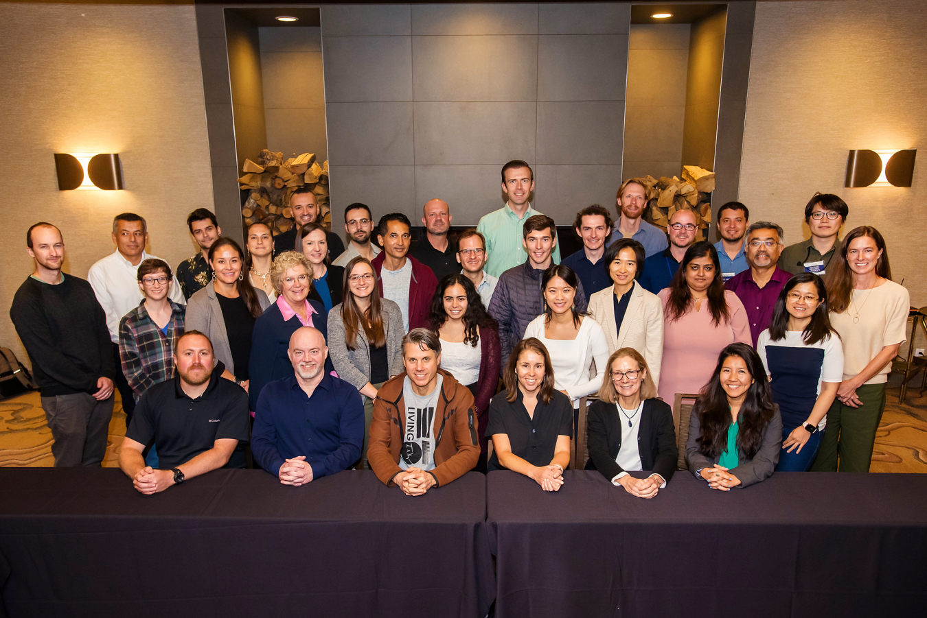 A group of 34 people pose and smile for the camera.