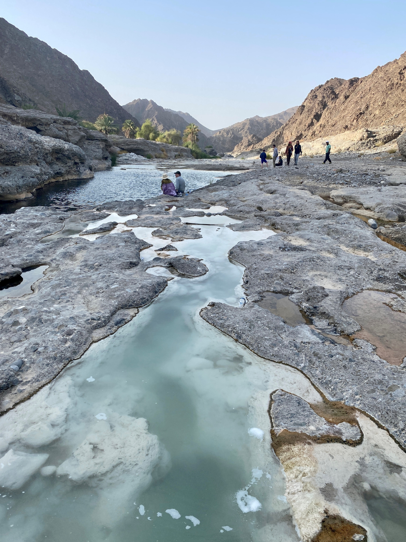 In the foreground, hydrogen bubbles are visibly seeping through the waters of a spring in Oman.