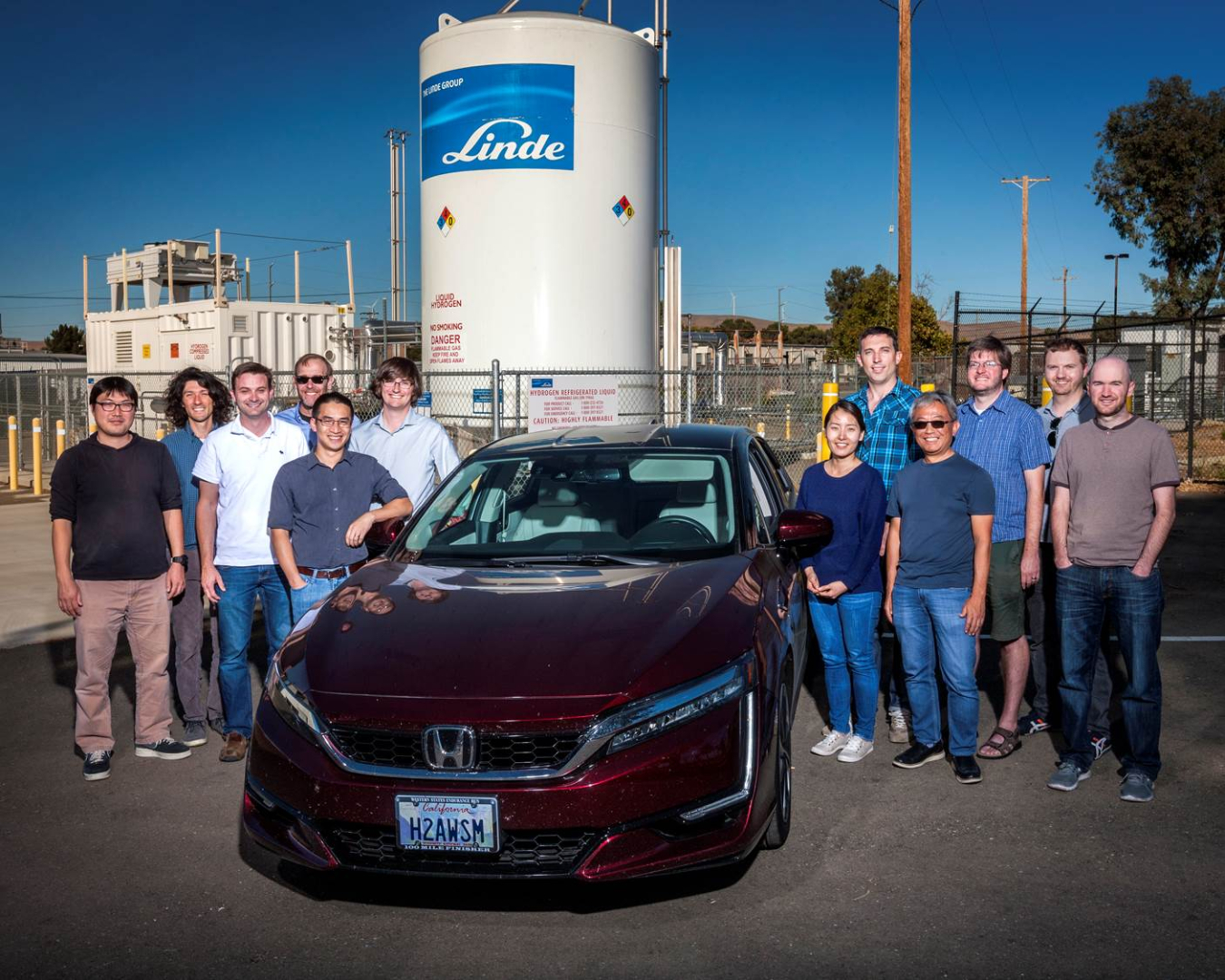 Team members from Lawrence Livermore National Laboratory stand around a passenger car.