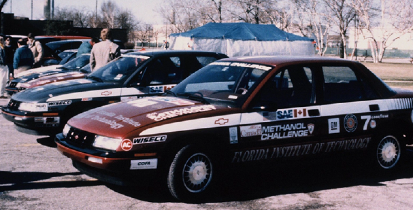 A row of 1988 Chevrolet Corsicas covered in stickers to show branding for the Methanol Challenge.