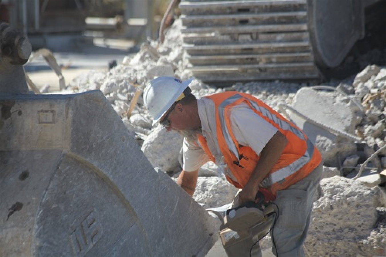 Worker sweeping excavator bucket