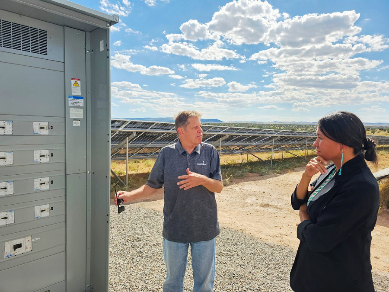 A man shows solar infrastructure to Office of Indian Energy Director Wahleah Johns.