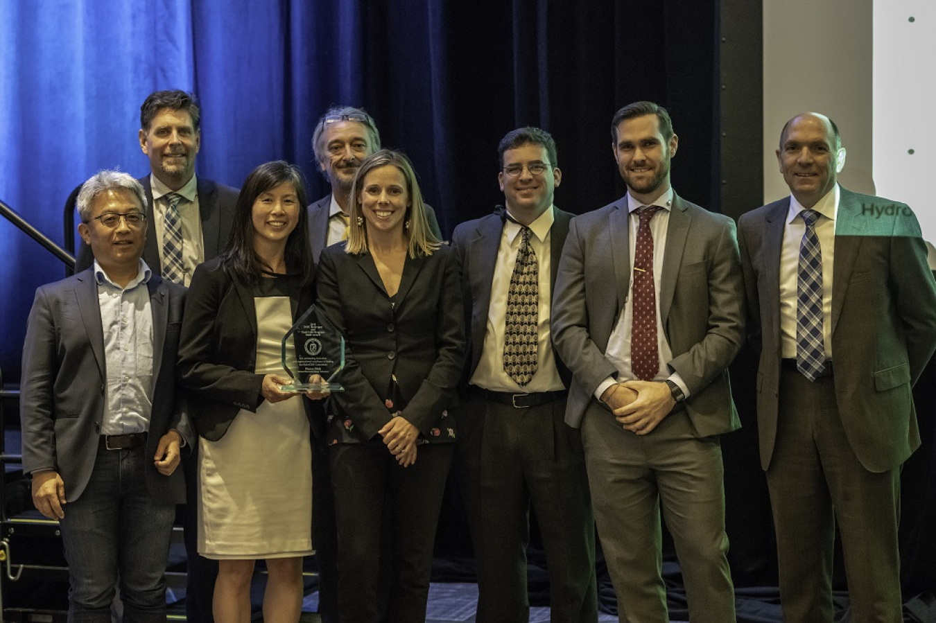 HydroGEN steering committee members smiling with a glass award. 