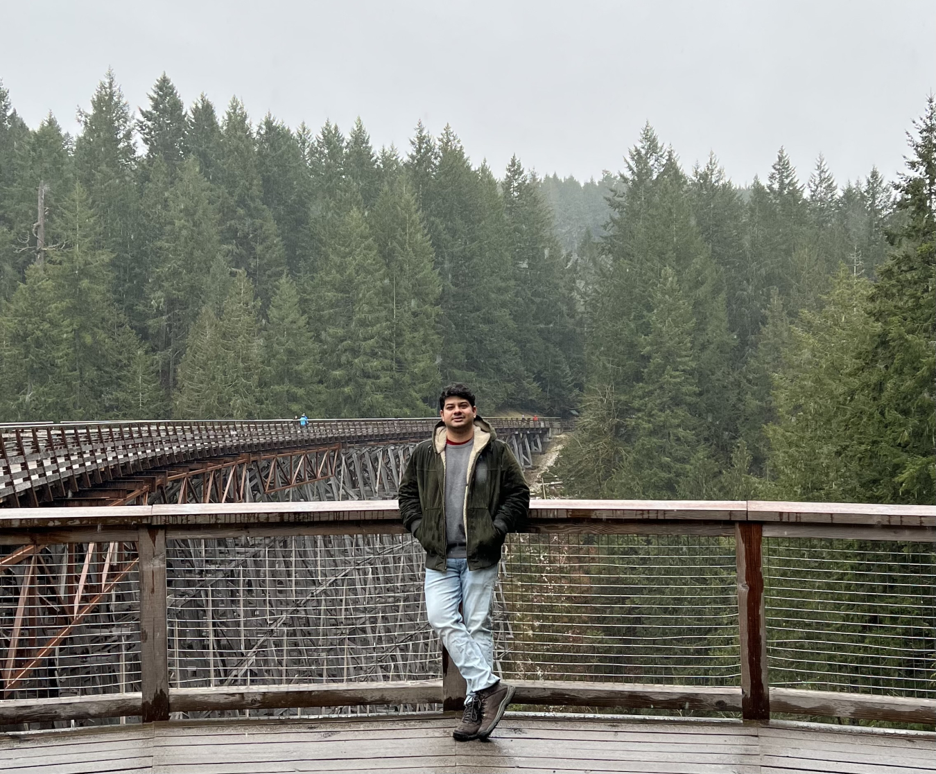 Sohom Datta standing on a wooden bridge in a forest