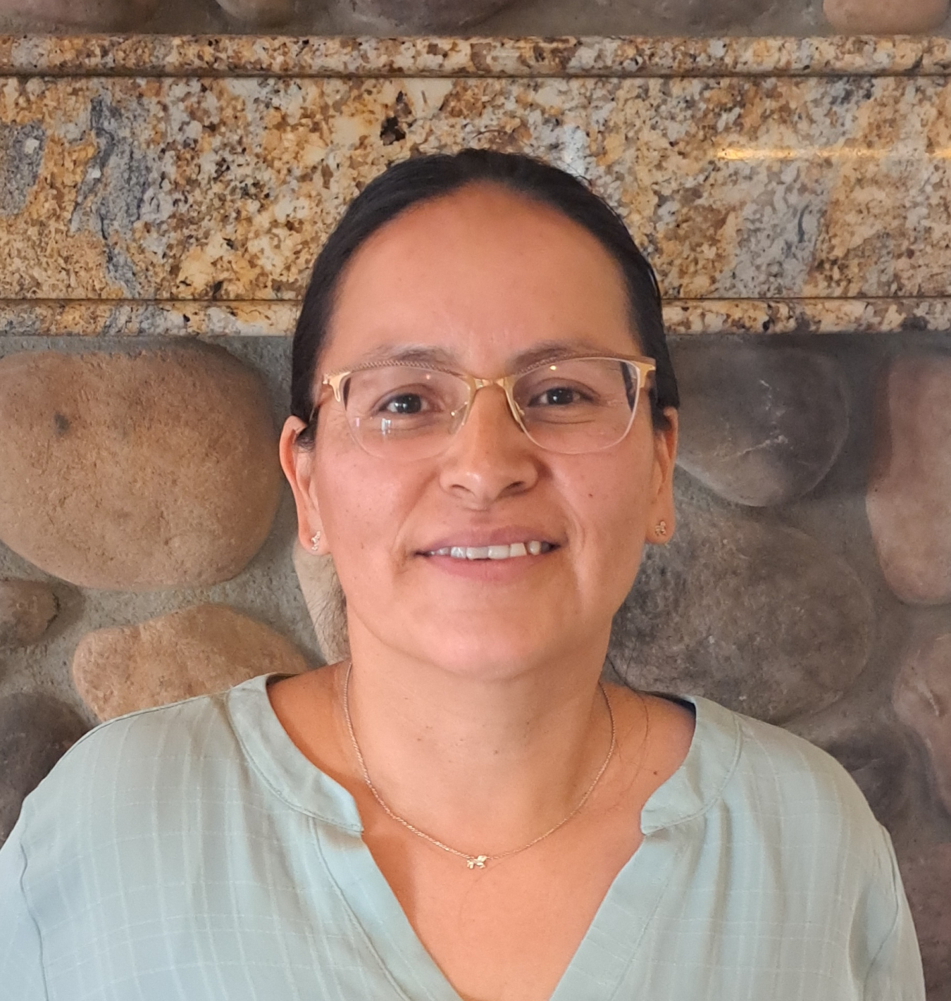 A portrait of a woman with black hair wearing glasses.