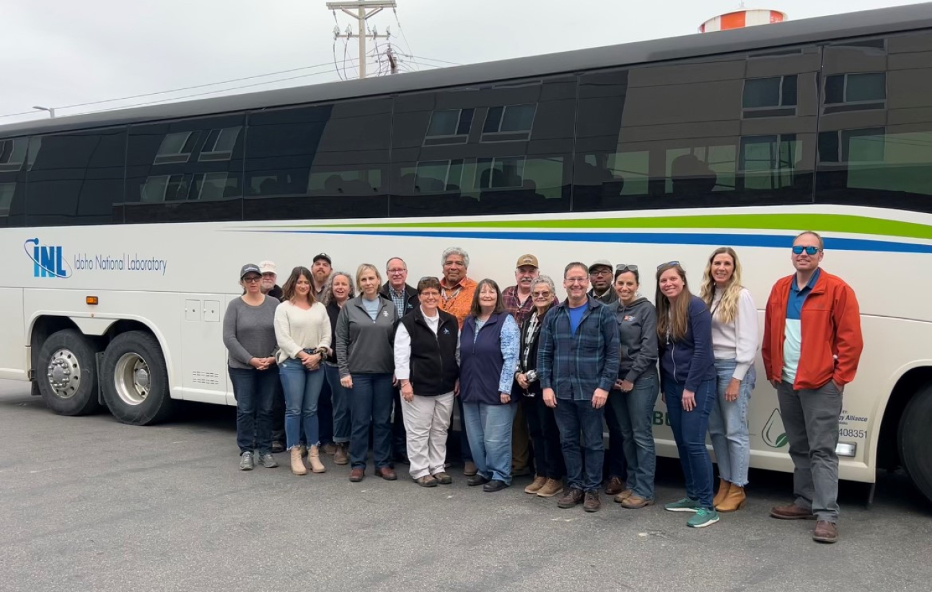 a group poses in front of a bus