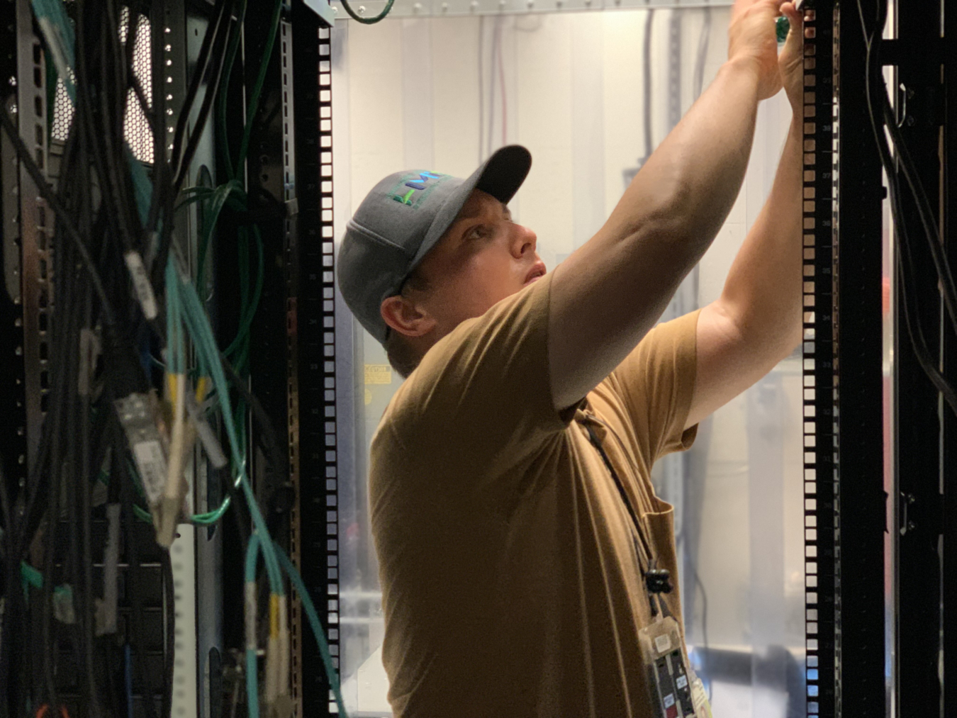 Person reaching up and working on electronics with his hands.