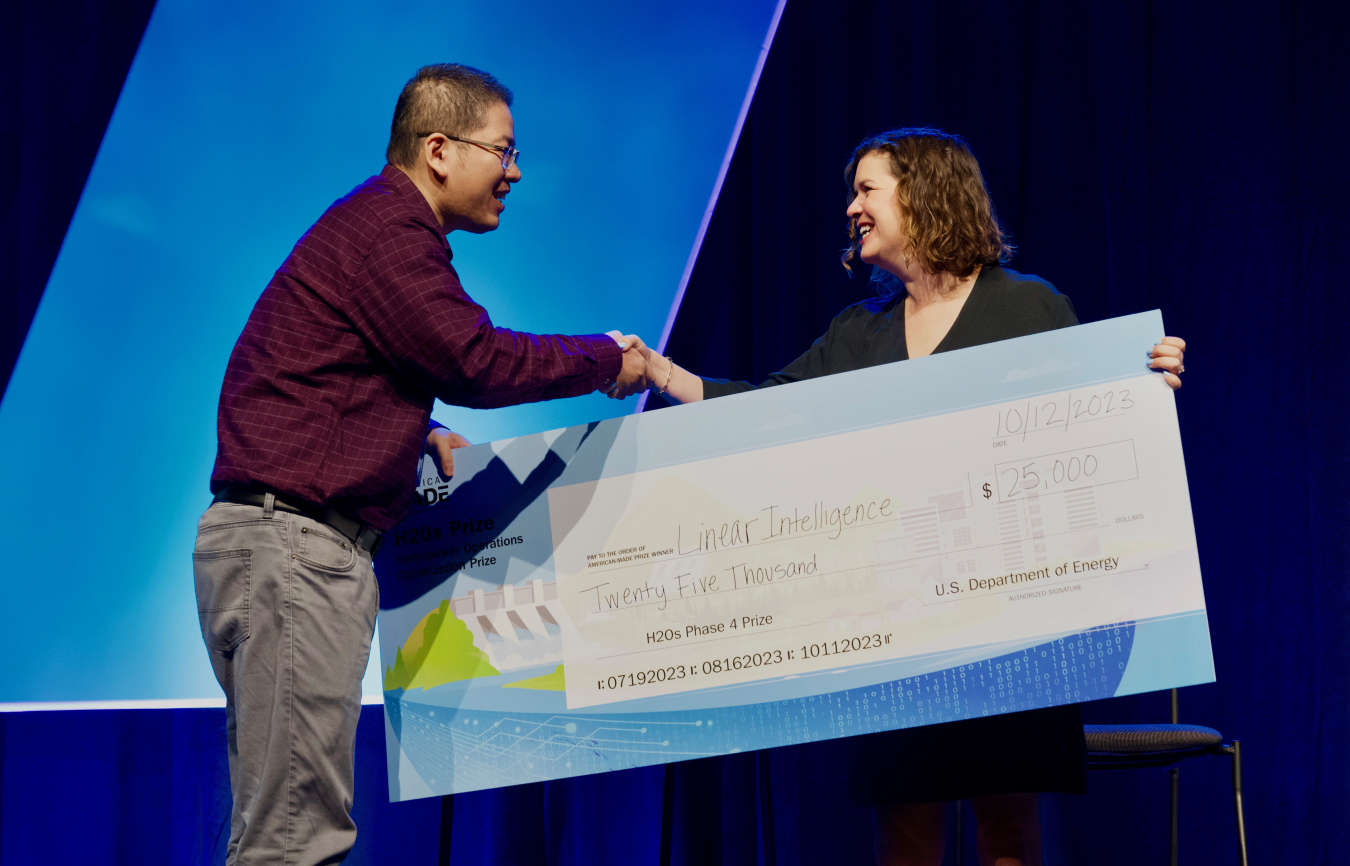 Woman handing a large check to a man