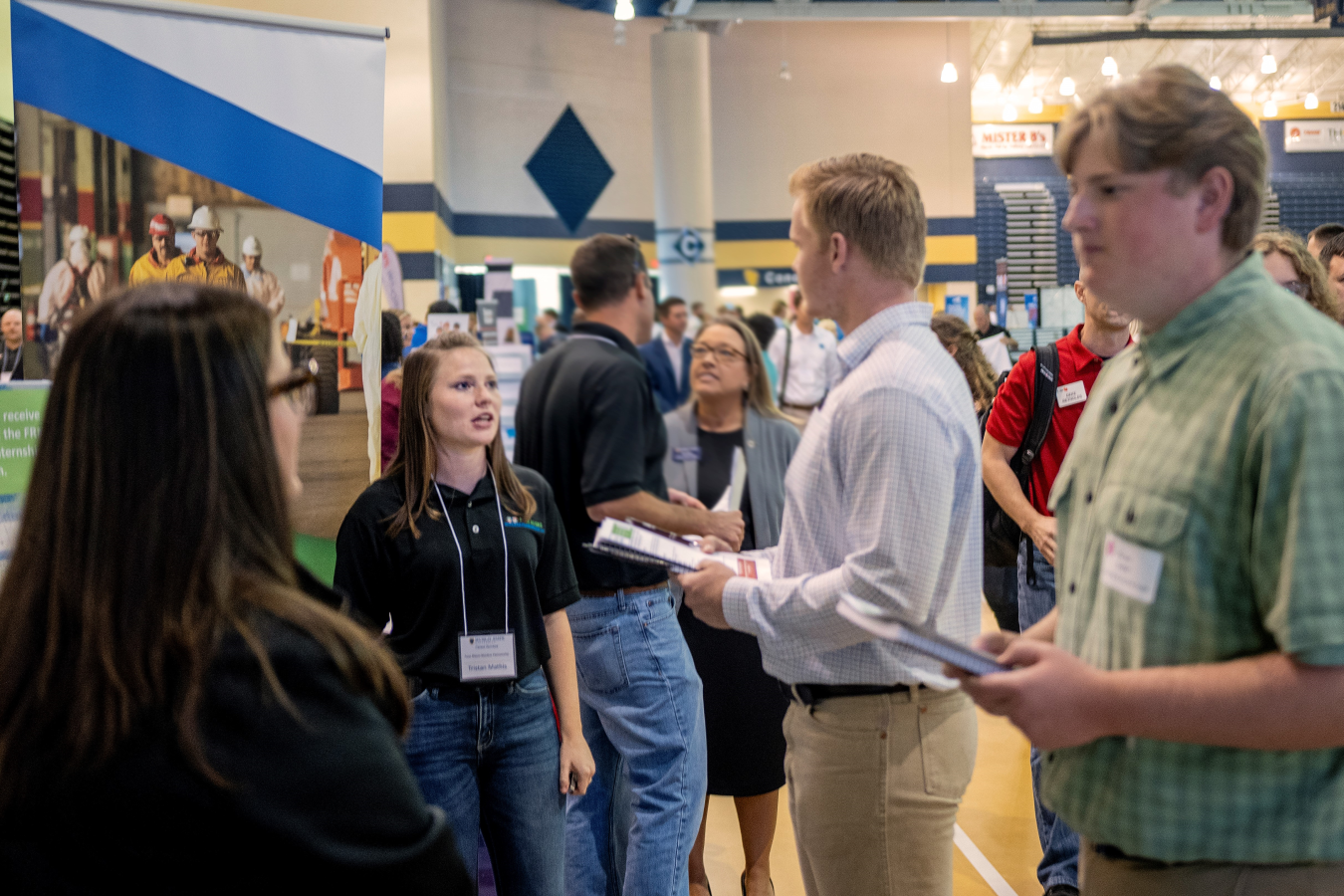 Students speak with women running booth