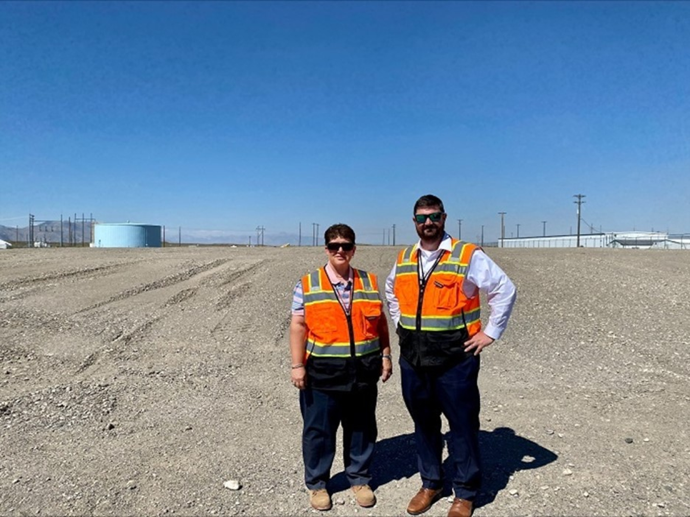 EM Idaho Cleanup Project Manager Connie Flohr and EM Principal Deputy Assistant Secretary Jeff Avery stand in front of the site where EM crews completed demolition of the waste exhumation facility that overlaid Pit 9