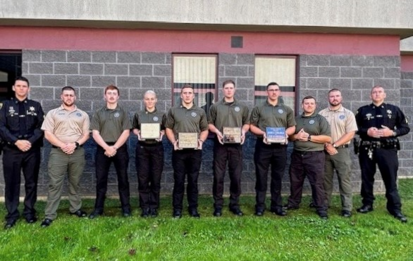 Security police officer graduates pose for a picture with their instructors