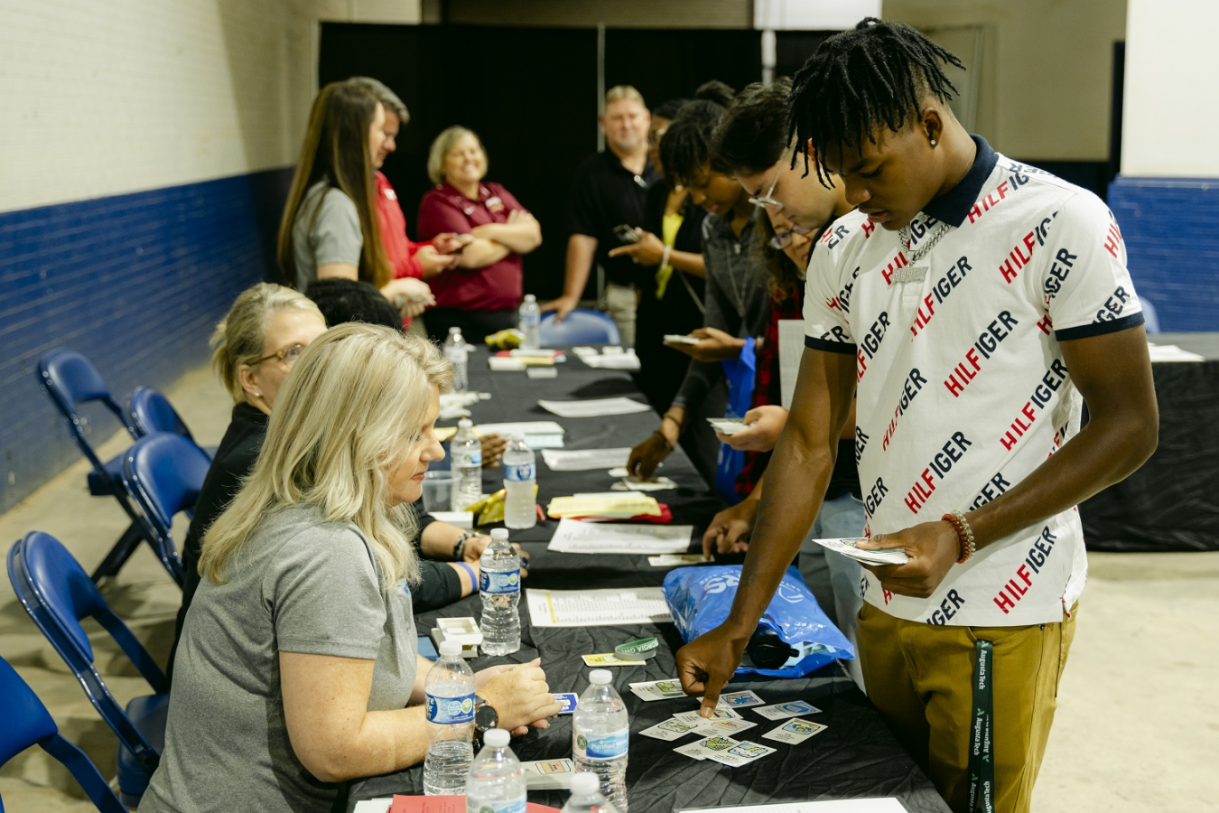 A student picks up information cards from a booth at the event