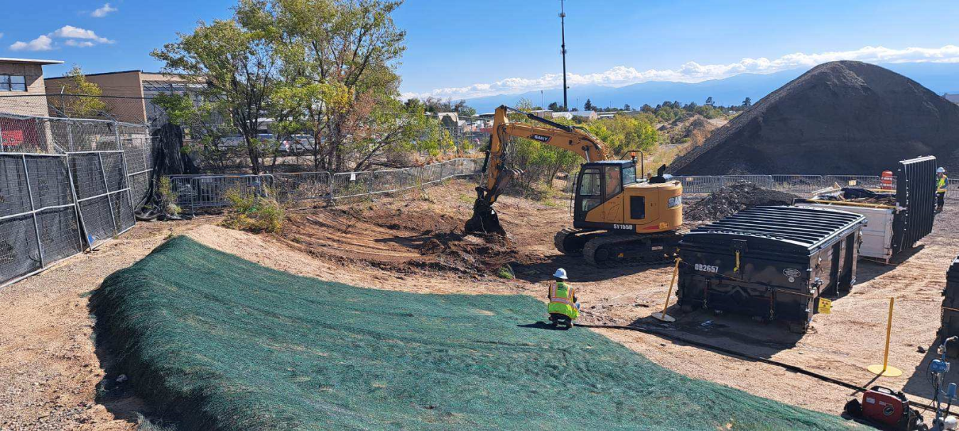 Photo of construction equipment working outside in the dirt