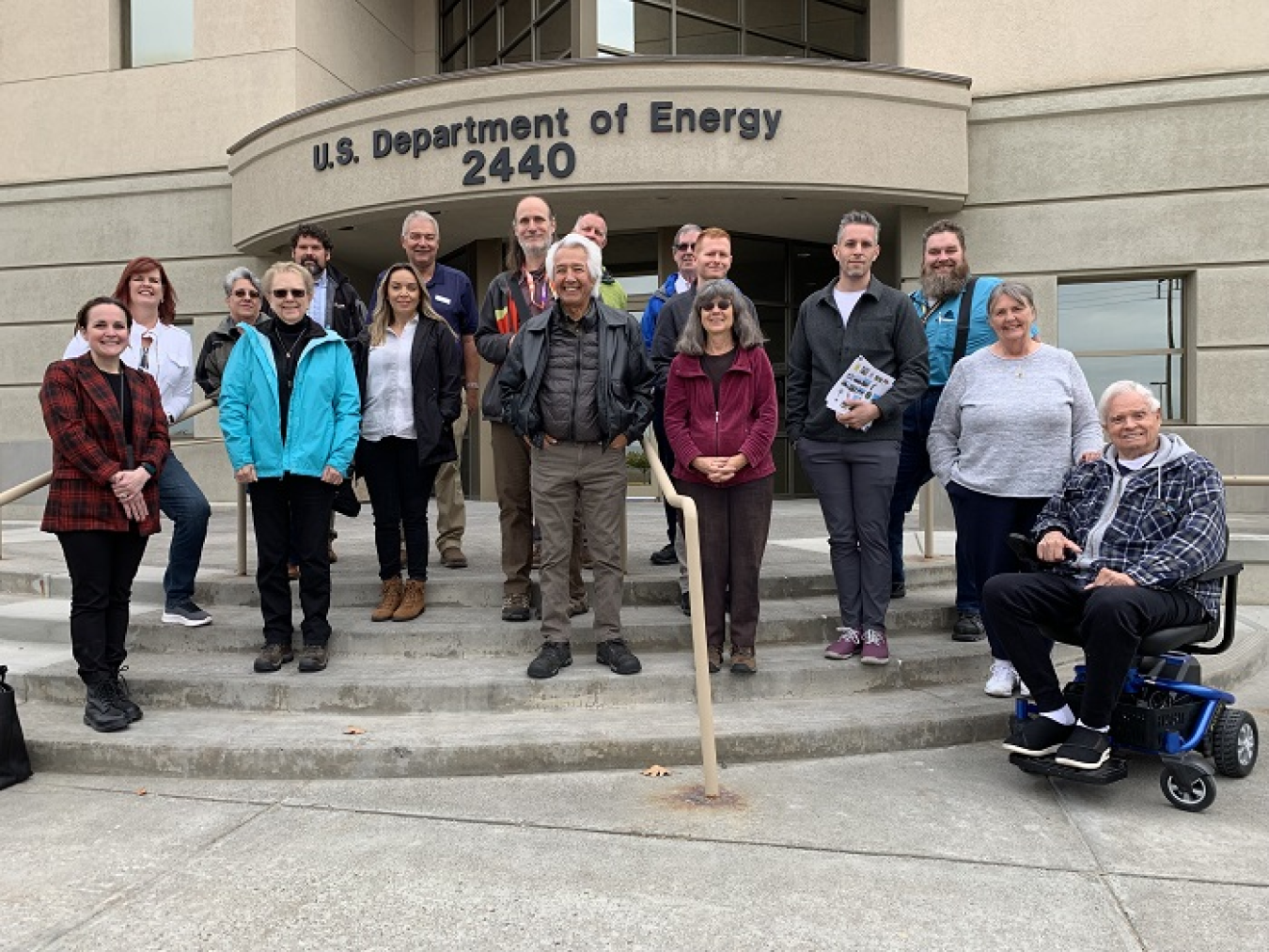 Group of people pose in front of a building