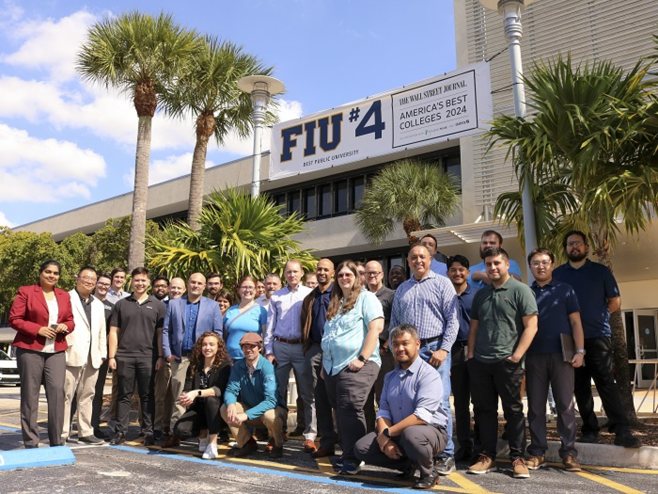 A group of people pose for a photo outside of a building