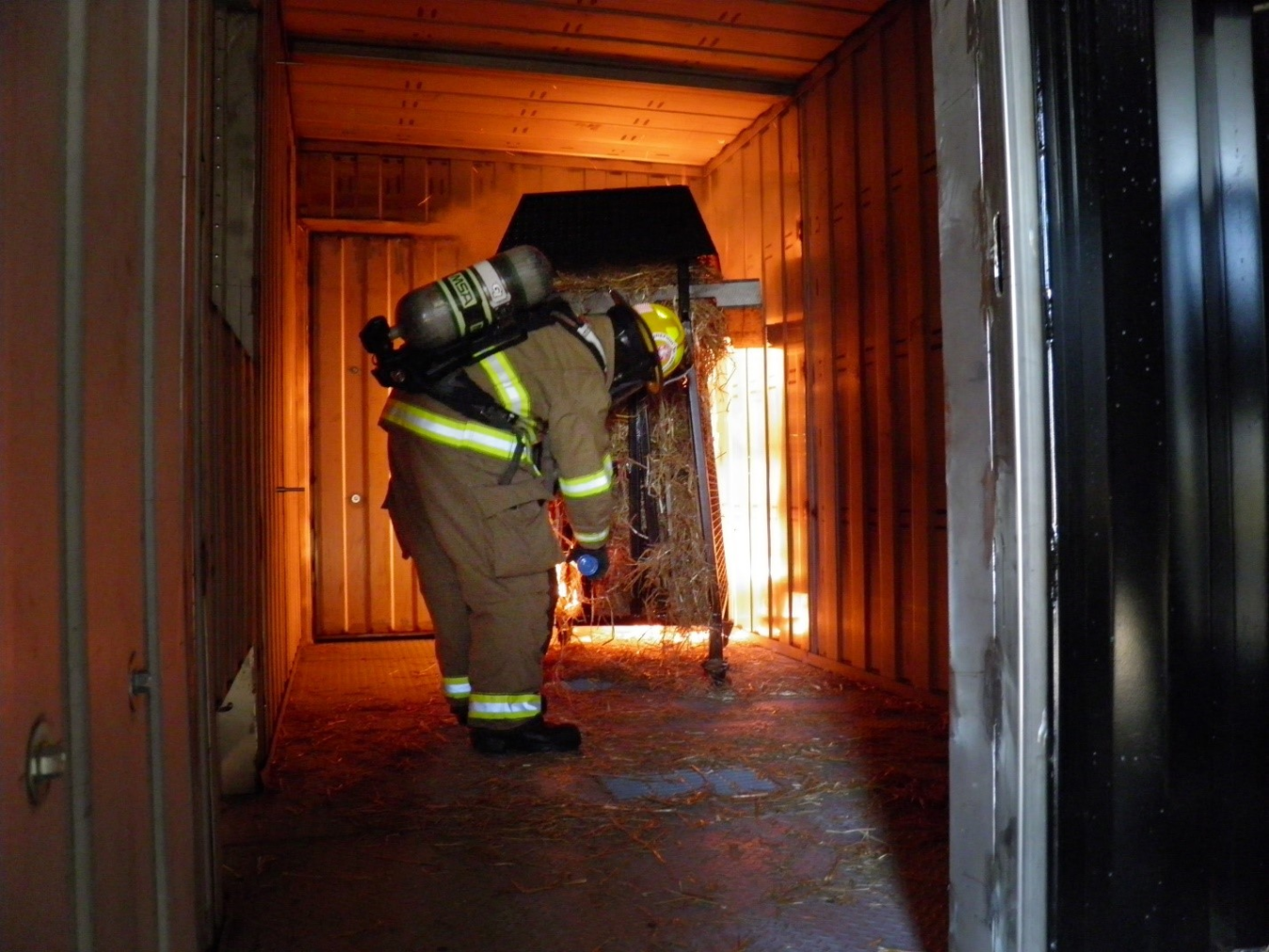 A firefighter lights a fire in a training building for an exercise