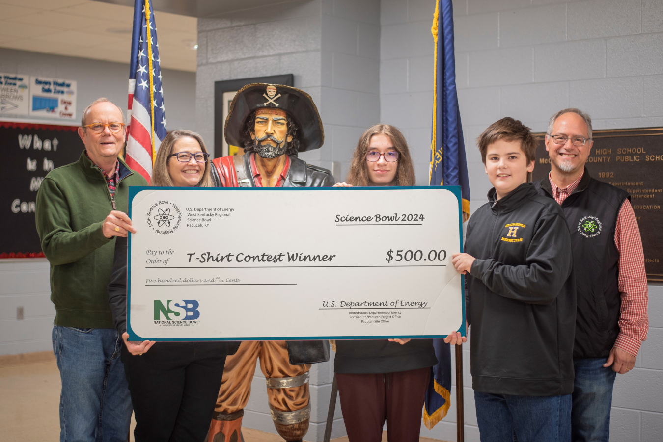 A group of people hold a large check and pose for a picture