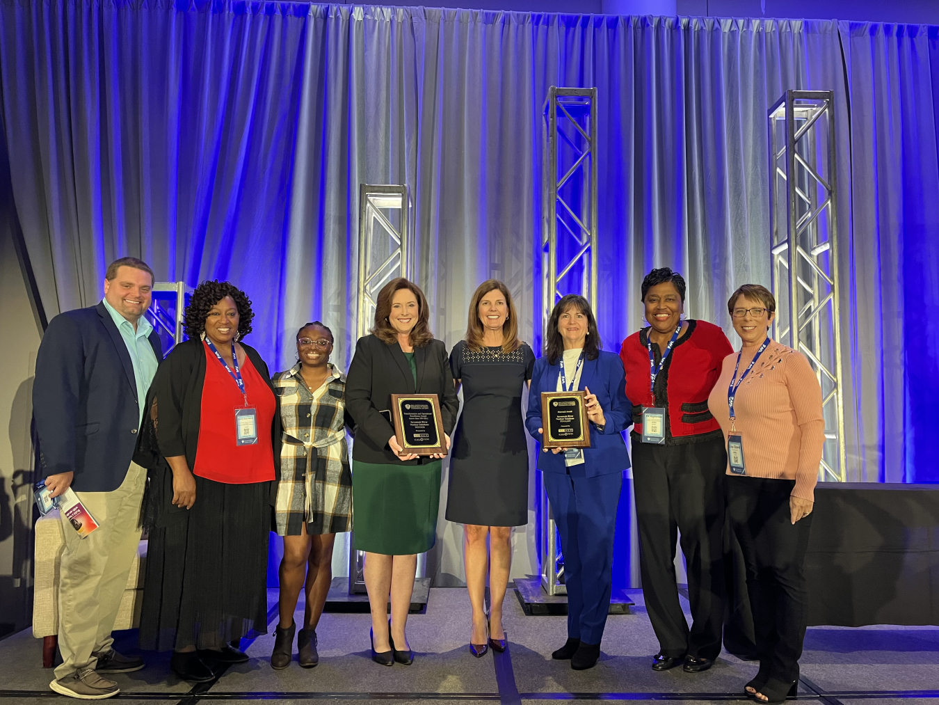 A group of people stand on a stage and accept an award