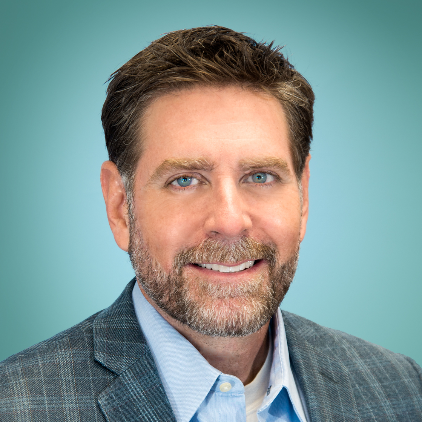 Anthony McDaniel, smiling and wearing a blazer with a collared shirt.