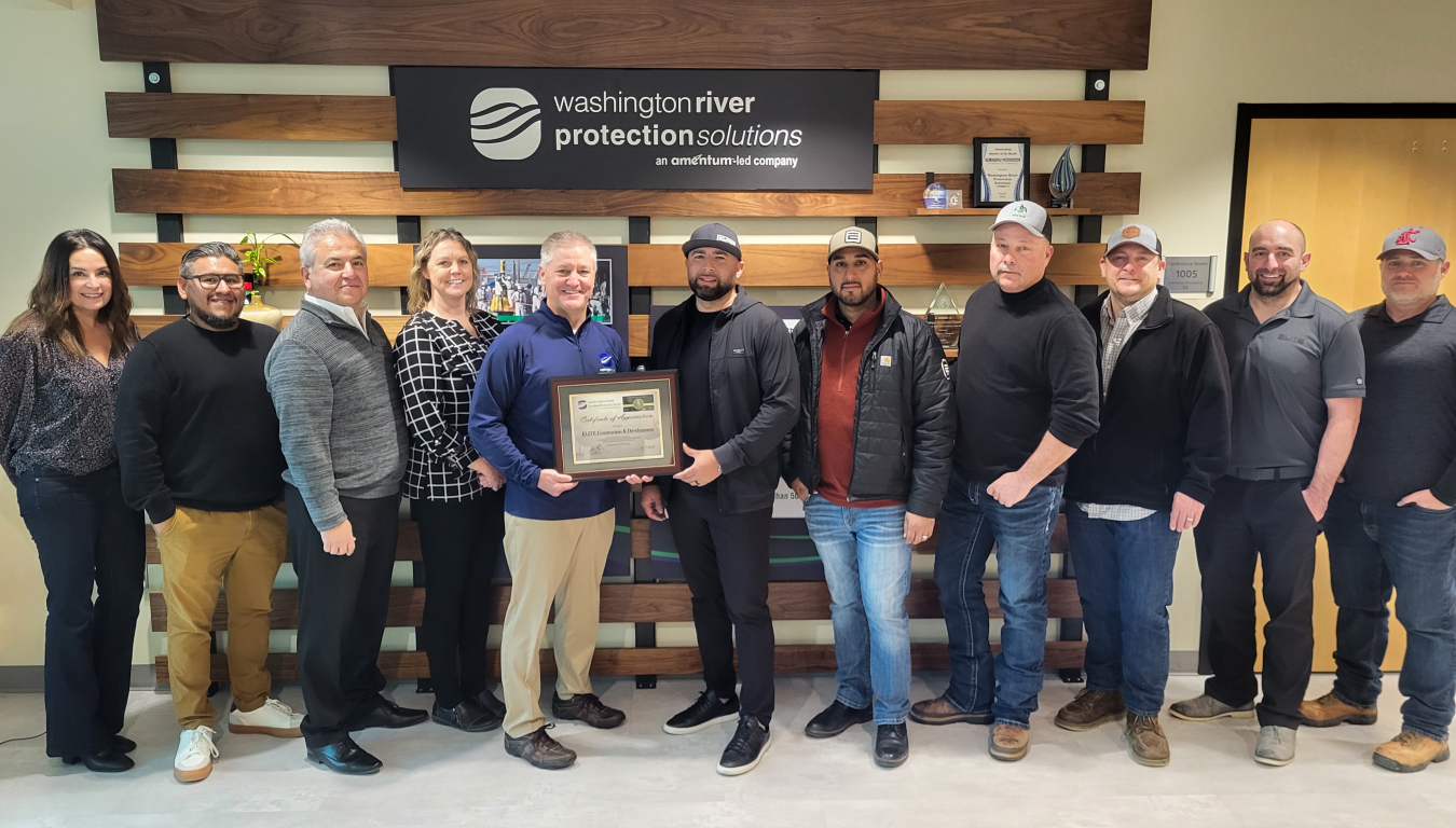 A large group of people pose for a photo with a certificate