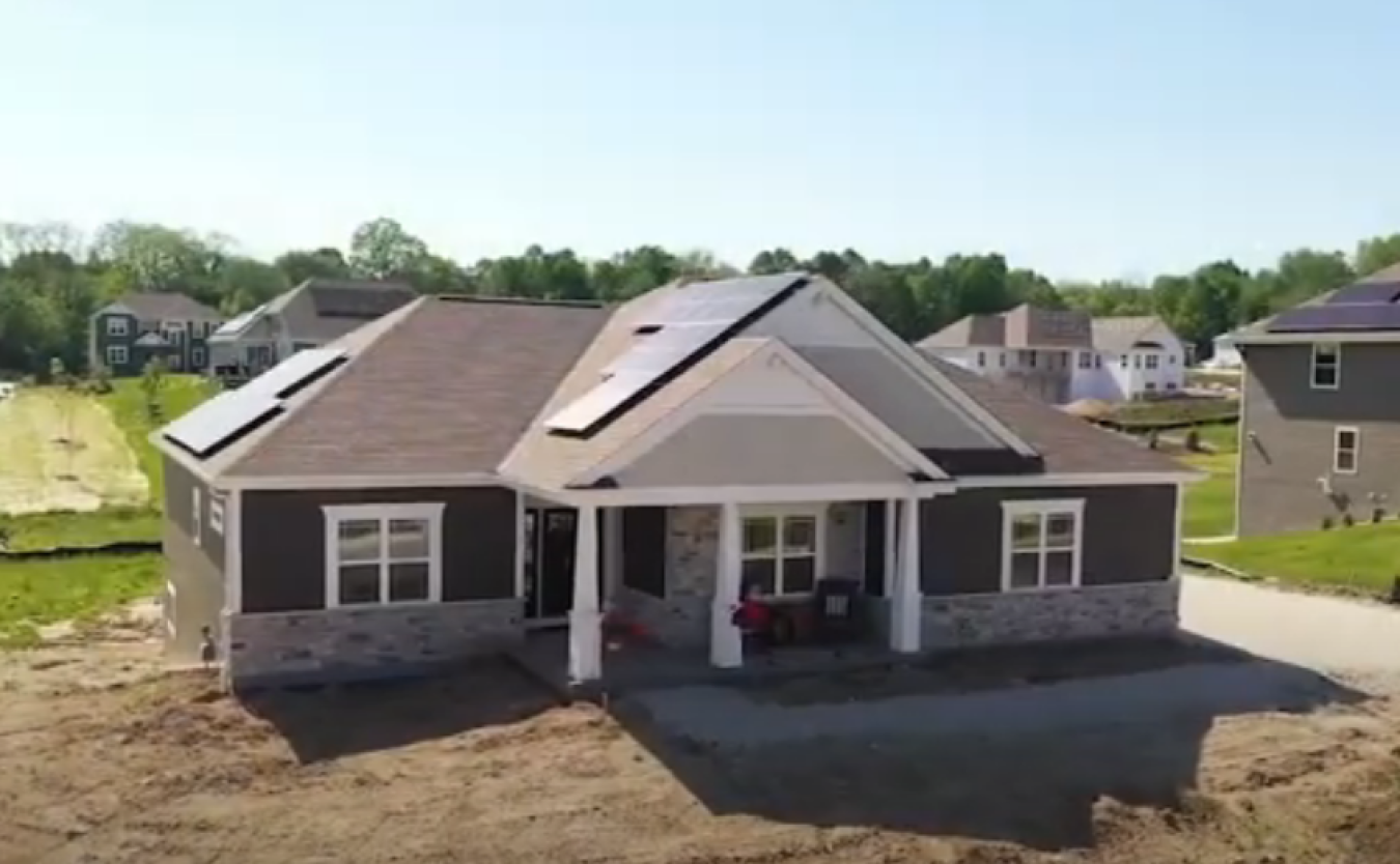 A newly built home on a development site with other homes around it.