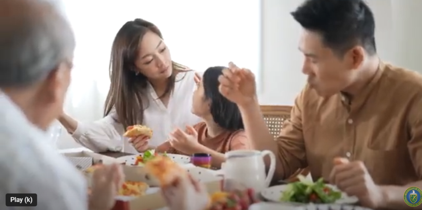 A family sitting at the dinner table together and interacting.