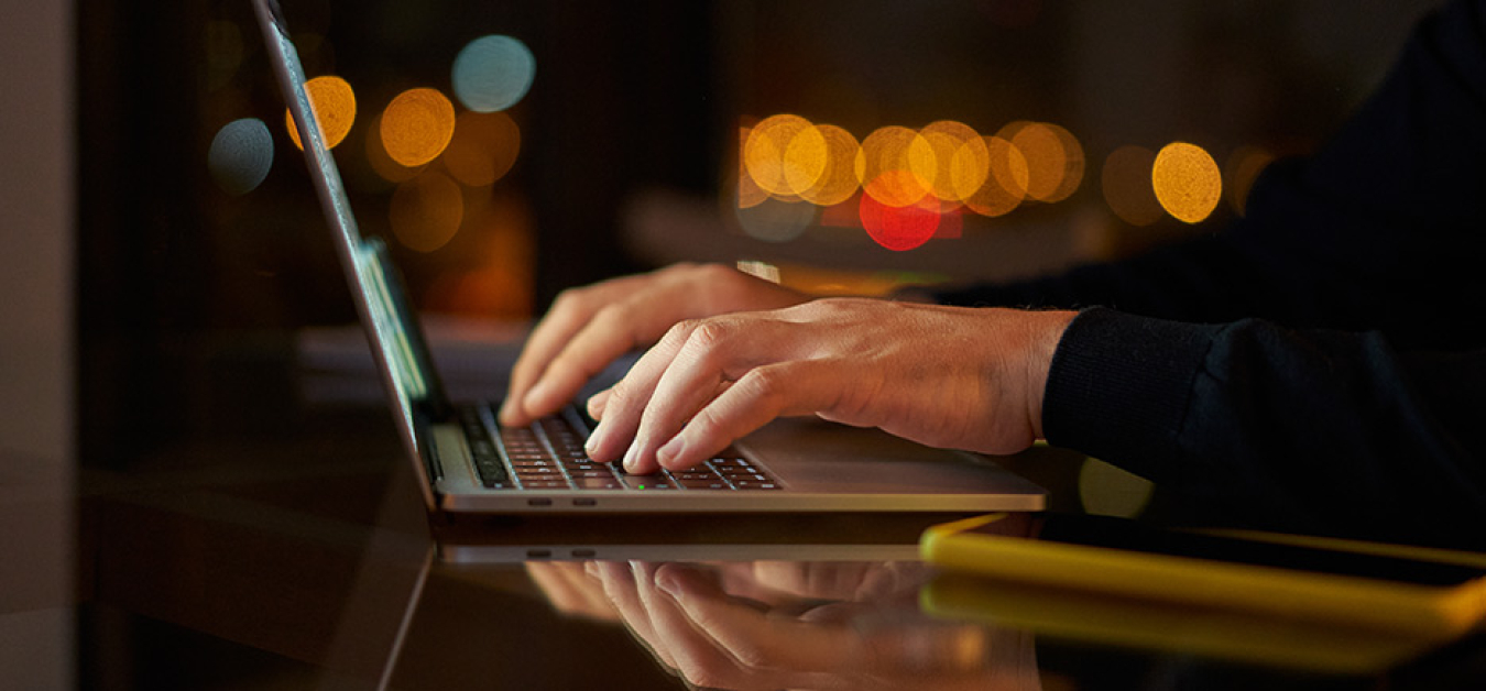 Close-up of hands typing on laptop computer.