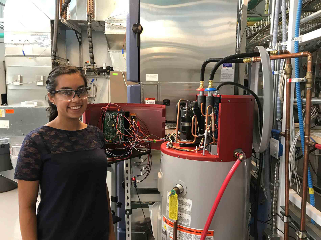 Jamie Santos standing next to residential water heater