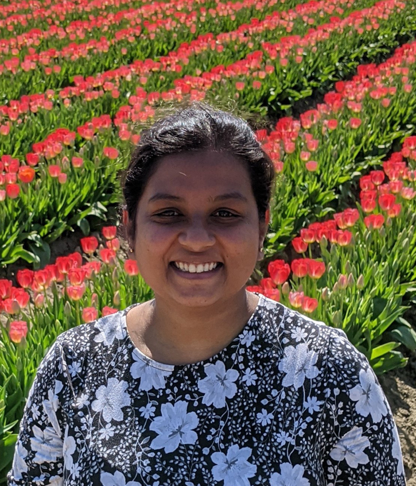 Chinmayee Subban standing in front of a field of tulips