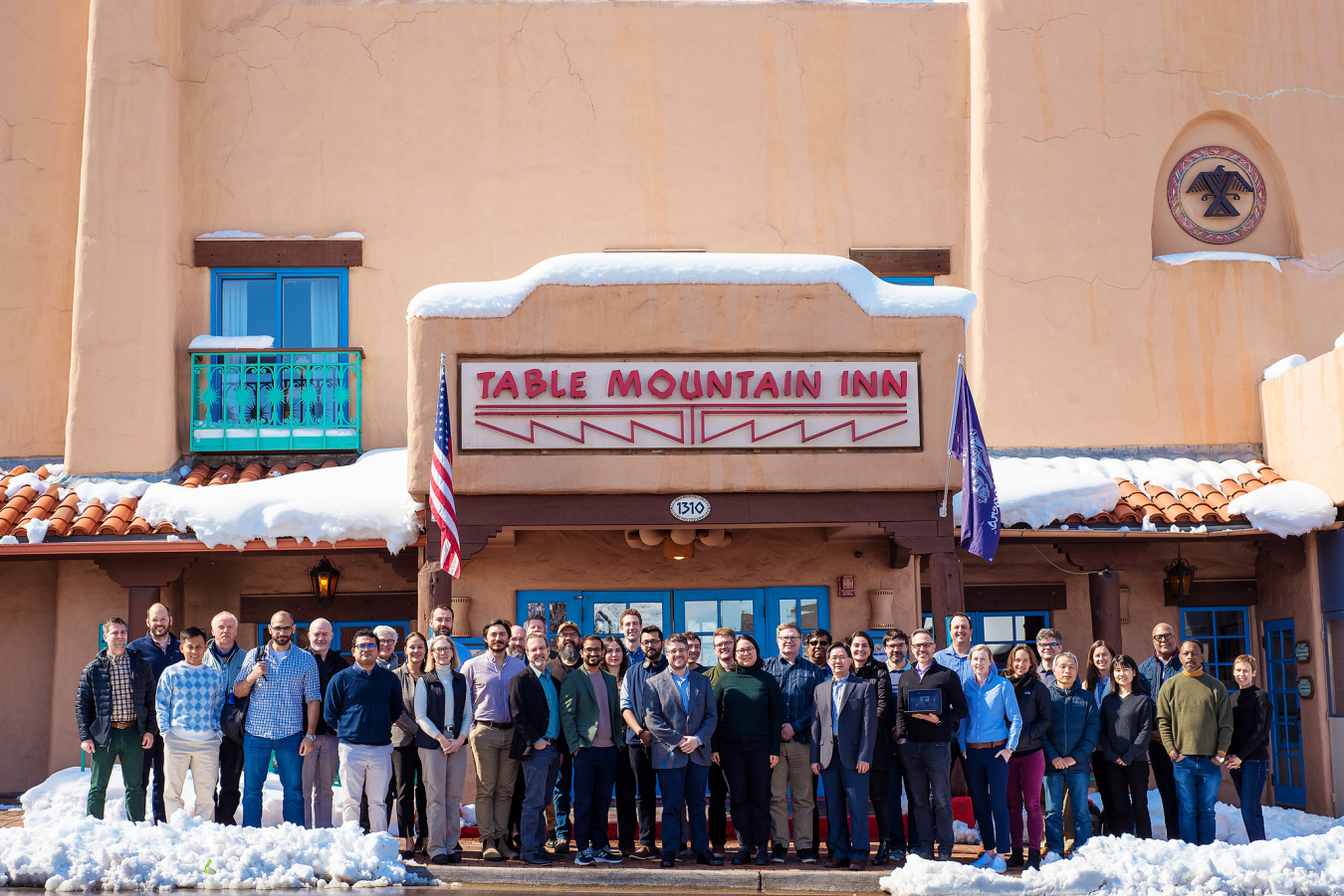 A group of 40 people stand and pose in front of a building.