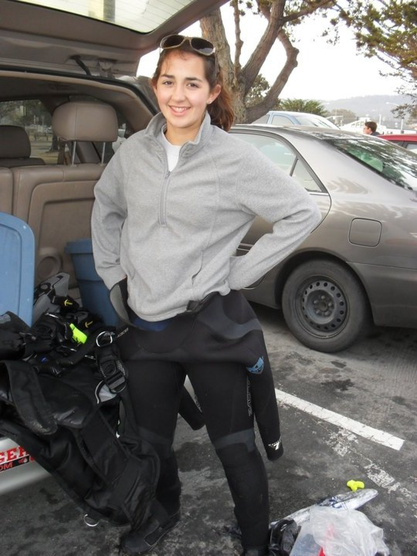 Claire Gonzales posing in wetsuit and sweatshirt